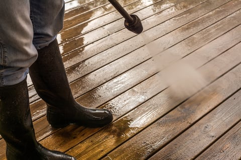 Cleaning Patio Decking wearing dirty rubber boots.
